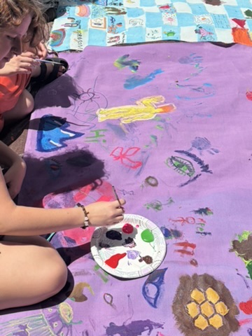 A participant painting a purple Surface/Self canvas.