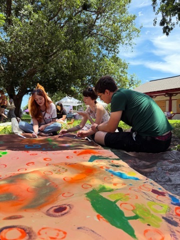 Participants painting Surface/Self canvases outdoors.