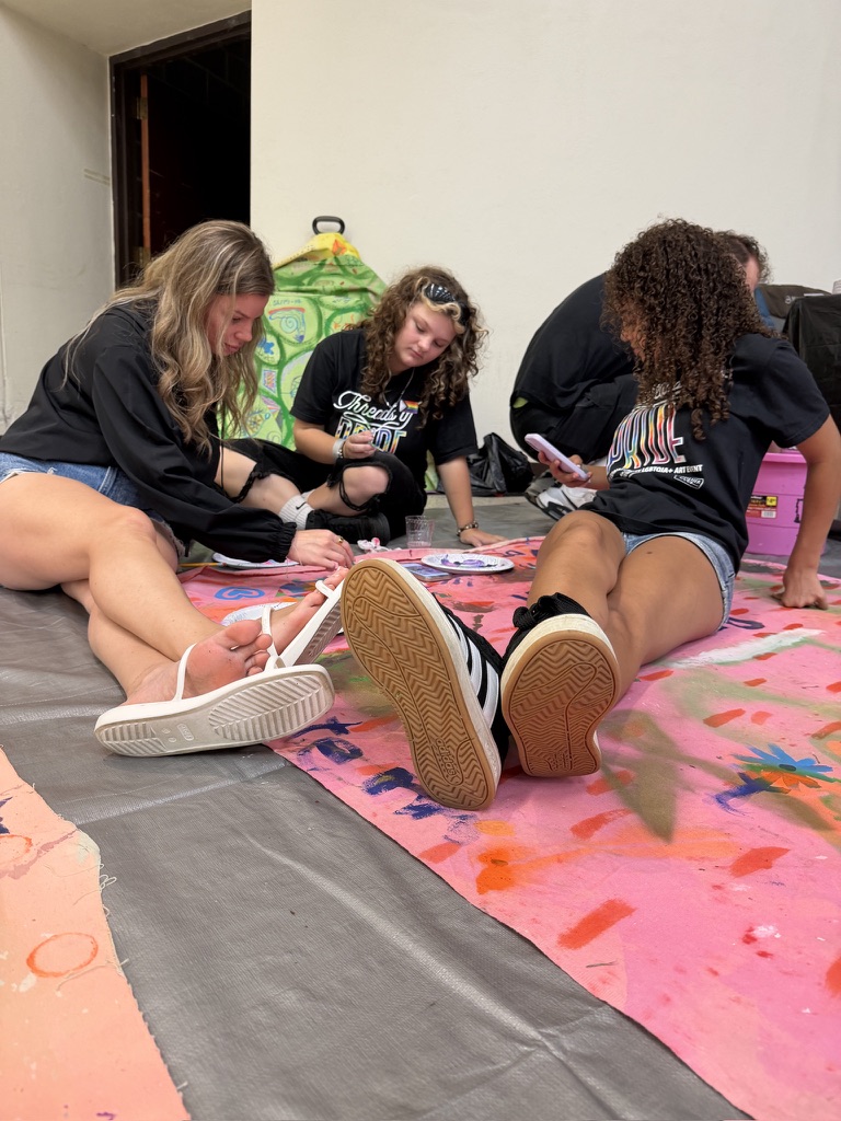 Youth participants painting Surface/Self canvases indoors.