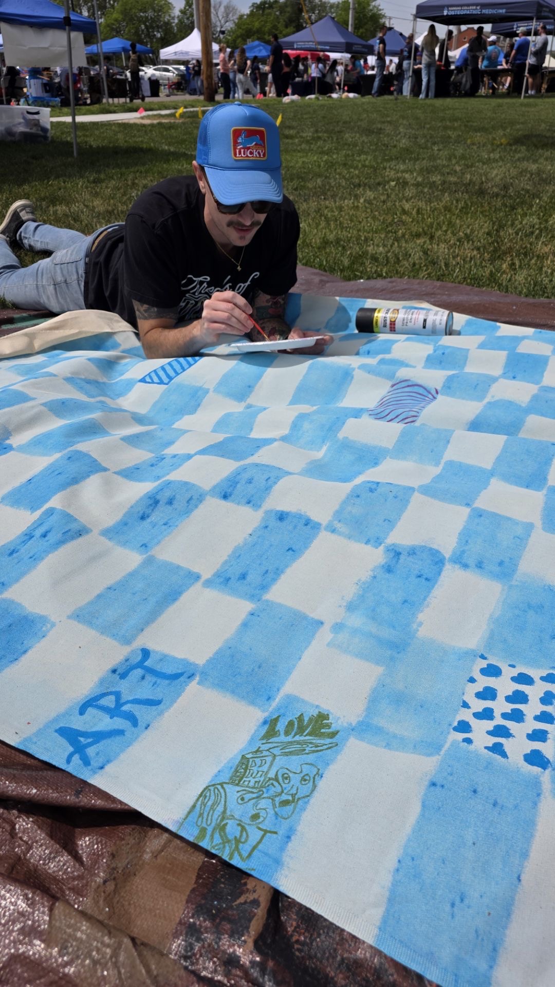 Michael K. Davenport painting a large community-created Surface/Self canvas.